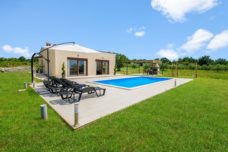 Modernes Ferienhaus mit Pool, Garten und schöner Landschaft.