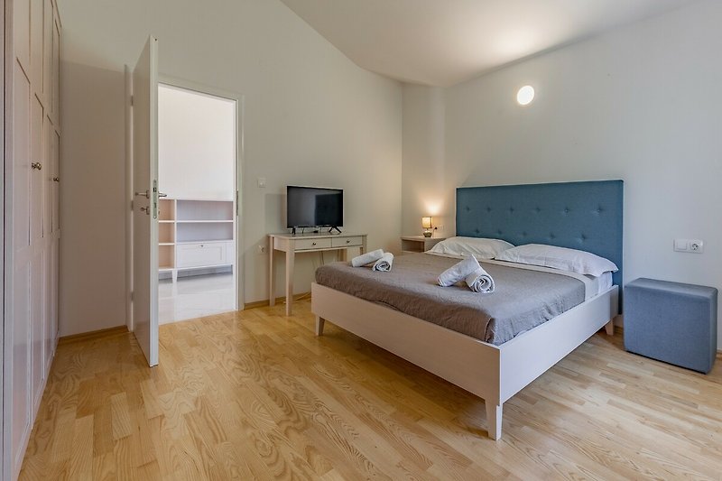Gemütliches Schlafzimmer mit Holzboden, bequemem Bett und stilvoller Einrichtung.