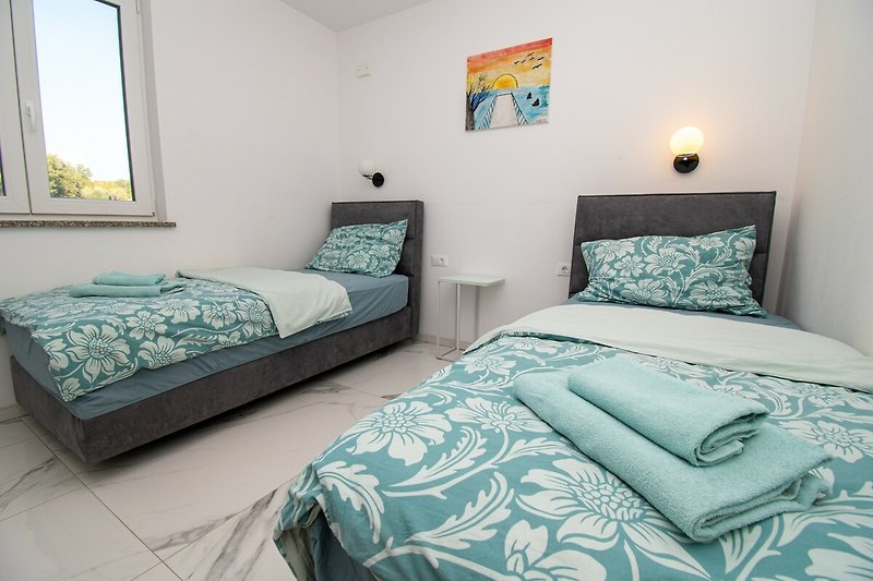 Gemütliches Schlafzimmer mit Holzmöbeln und blauem Fenster.