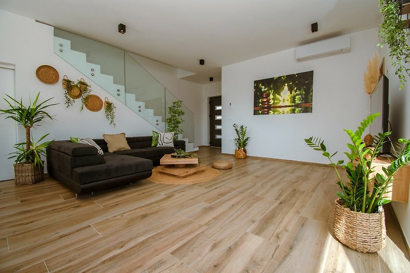 Wohnzimmer mit gemütlicher Einrichtung und Pflanzen.