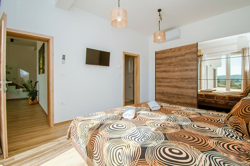 Wohnzimmer mit gemütlicher Einrichtung, Holzboden und Kunst.