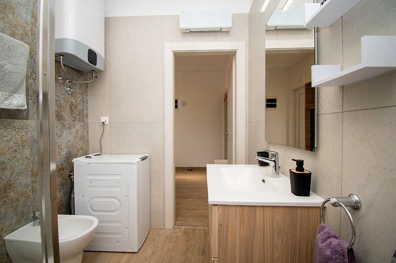 Schönes Badezimmer mit weißem Waschbecken, Spiegel und lila Boden.