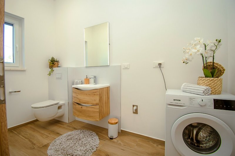 Badezimmer mit Spiegel, Waschbecken und Pflanze - modernes Design!