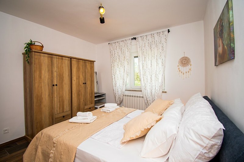Schlafzimmer mit gemütlichem Bett und Holzmöbeln - stilvoll eingerichtet!