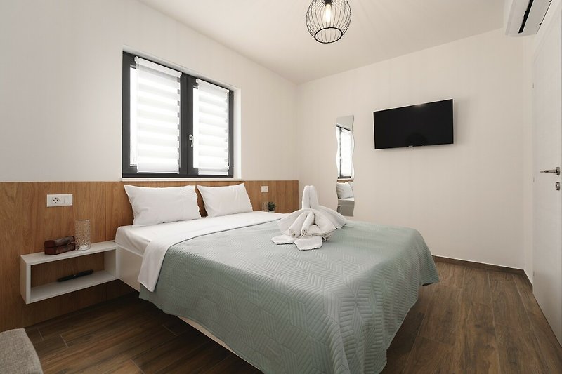 Modernes Schlafzimmer mit gemütlichem Bett, stilvoller Beleuchtung und Holzmöbeln.