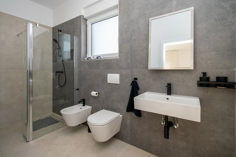 Modernes Badezimmer mit lila Akzenten, Spiegel und Fenster. Ideal für Entspannung.