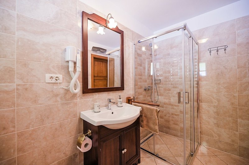 Modernes Badezimmer mit Glasdusche und Fliesen - stilvoll gestaltet!