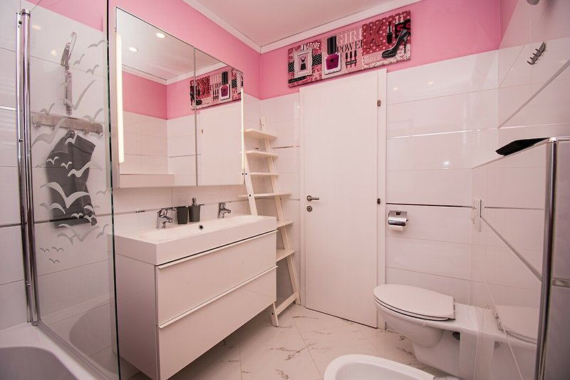 Ein lila Badezimmer mit stilvoller Inneneinrichtung und Spiegel.