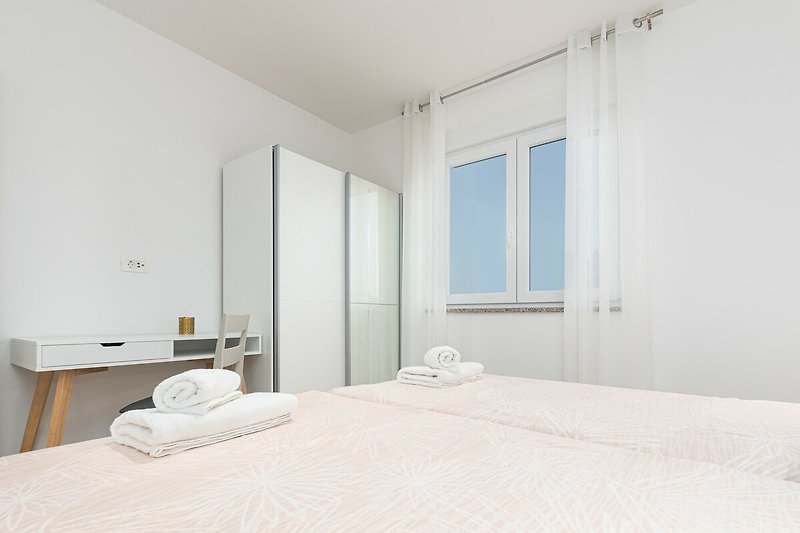 Elegantes Schlafzimmer mit stilvollem Bett und Fenster.