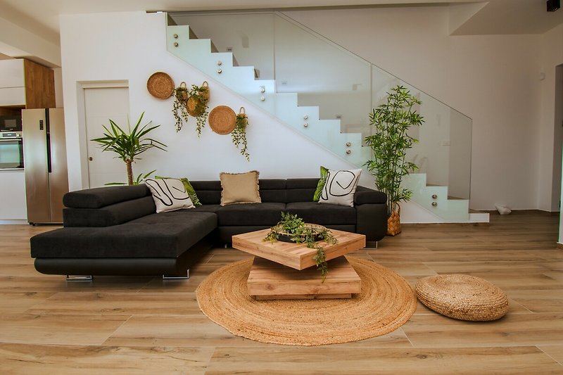 Wohnzimmer mit Pflanzen, Holz und Dekoration.