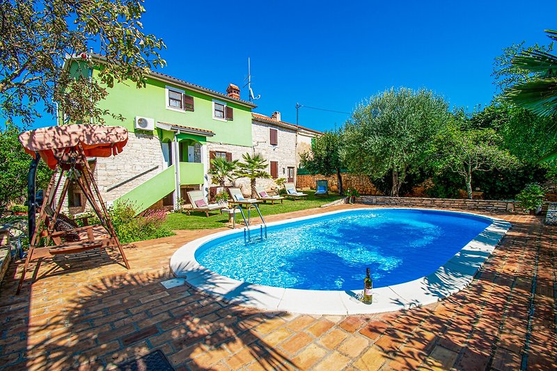 Geräumiger Garten mit Pool und Blick auf die Villa.