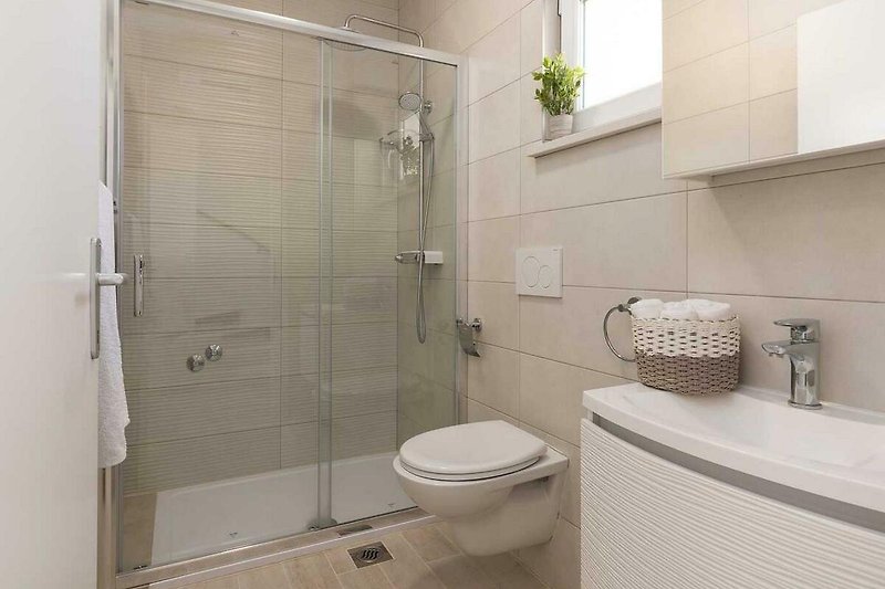 Badezimmer mit lila Akzenten, Dusche, Toilette und Pflanze - modern gestaltet!