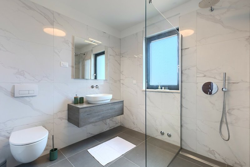 Ein stilvolles Badezimmer mit modernen Armaturen und Spiegel.