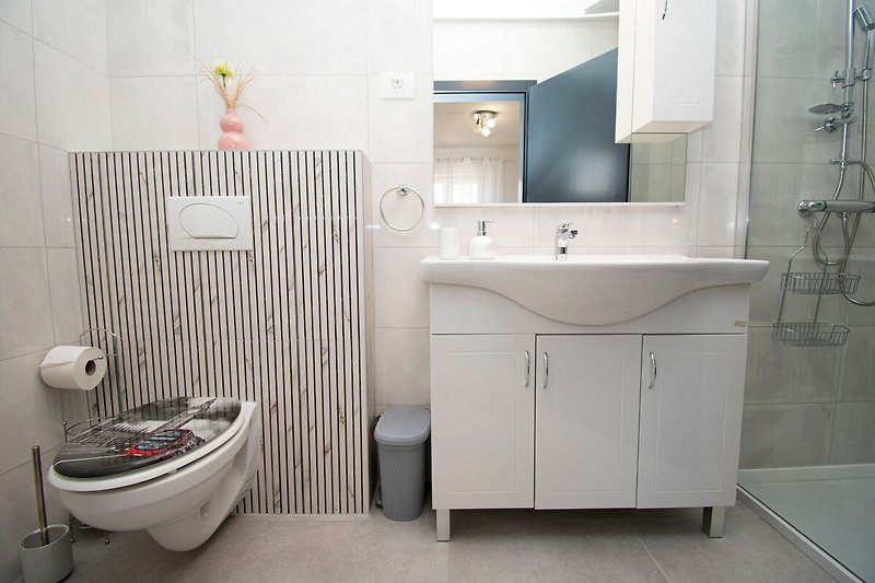 Schönes Badezimmer mit lila Armaturen und Spiegel.