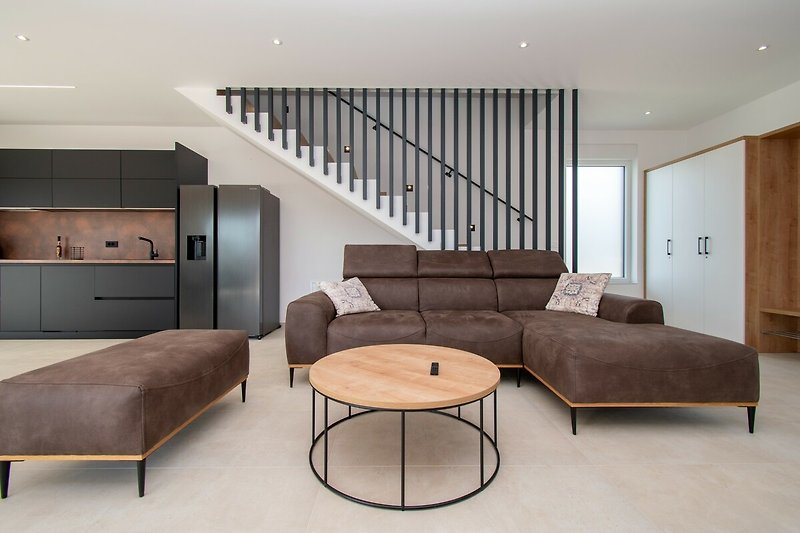 Stilvolles Wohnzimmer mit Holzmöbeln, gemütlicher Couch und Kunst. Ideal zum Entspannen!