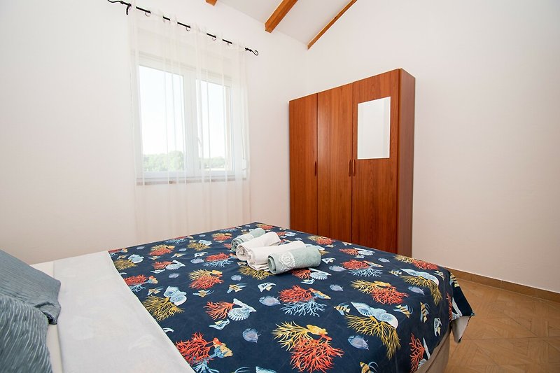 Gemütliches Schlafzimmer mit bequemem Bett und stilvoller Holzeinrichtung.