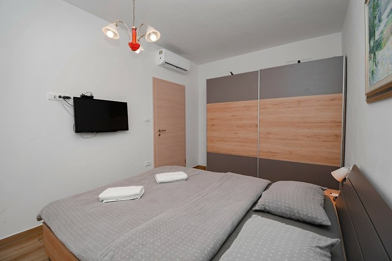 Holzbett mit stilvollem Interieur und gemütlicher Bettwäsche.