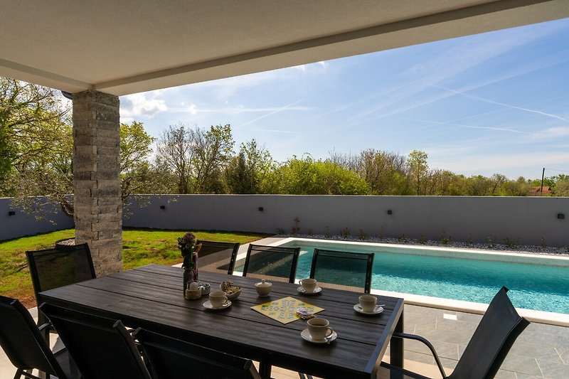 Ferienhaus mit moderner Einrichtung, Pool und Blick auf den Himmel.