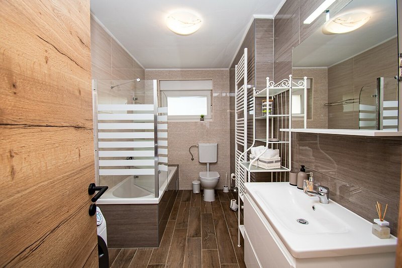 Modernes Badezimmer mit Badewanne, Waschbecken und elegantem Design.