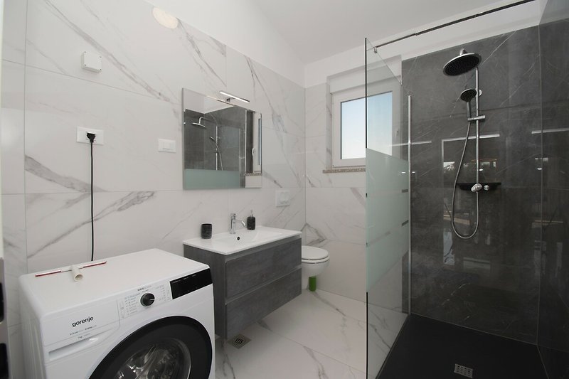 Modernes Badezimmer mit stilvollem Design, Spiegel und Armaturen.
