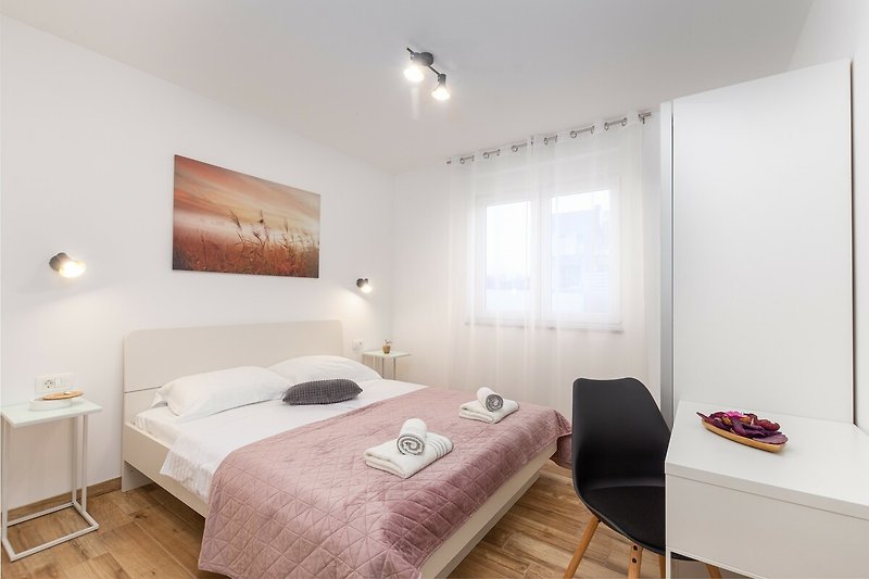 Modernes Schlafzimmer mit elegantem Holzbett, stilvoller Beleuchtung und gemütlicher Bettwäsche.