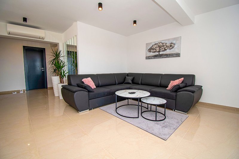 Gemütliches Wohnzimmer mit stilvoller Einrichtung, Holzboden und grauen Möbeln. Perfekt zum Entspannen und Wohlfühlen.