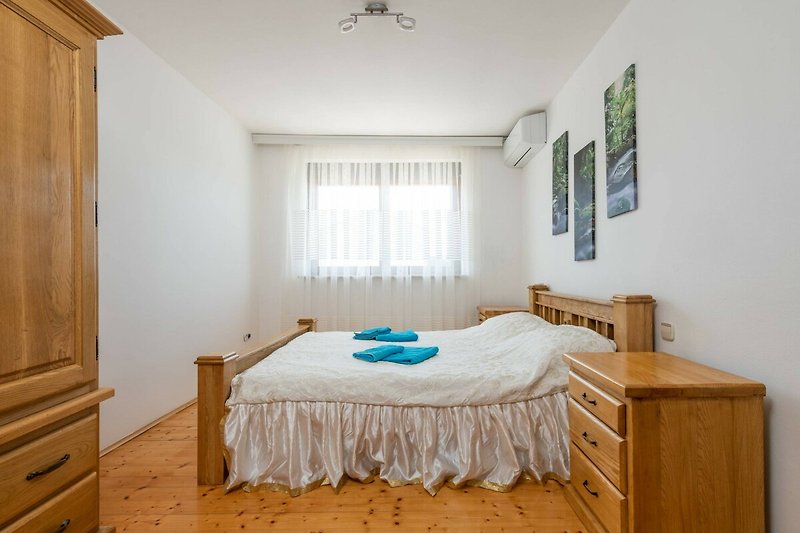 Schönes Schlafzimmer mit Holzboden und gemütlichem Bett.