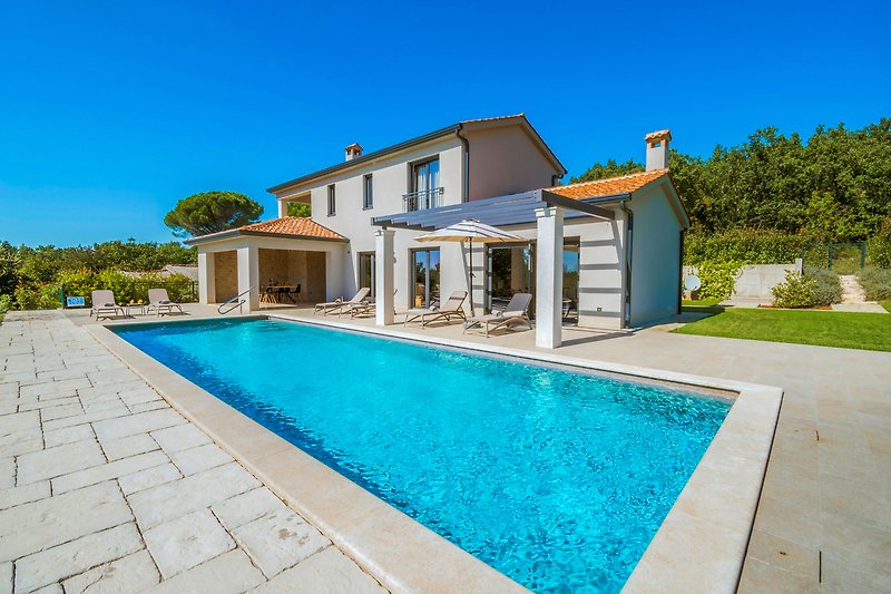 Ein idyllisches Ferienhaus mit Pool und Blick auf das azurblaue Wasser.