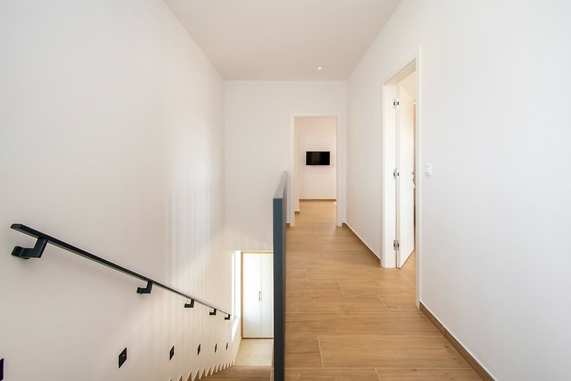 Moderne Wohnung mit Holzdetails, Treppe, Fenster und Handlauf. Ideal für Stadtliebhaber!