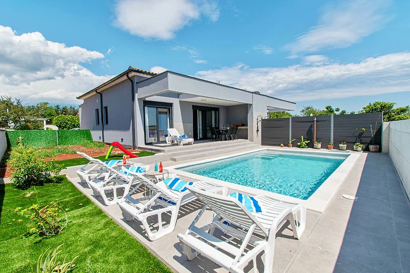 Villa mit Pool, Wasserfeature und gepflegter Landschaftsgestaltung.