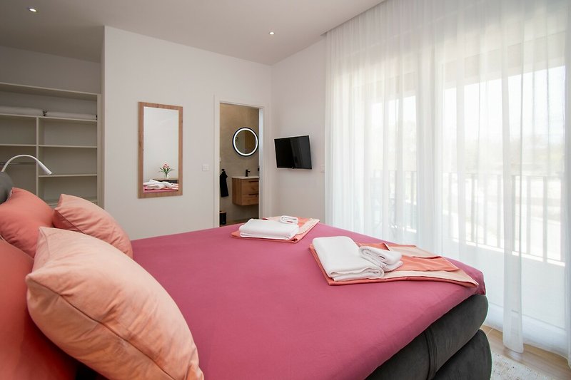 Modernes Schlafzimmer mit stilvollem Bett, gemütlicher Einrichtung und dekorativen Kissen. Gemütliche Atmosphäre.