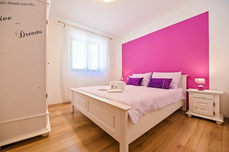 Gemütliches Schlafzimmer mit Holzmöbeln, Bett, Fenster und Dekoration - stilvoll eingerichtet!