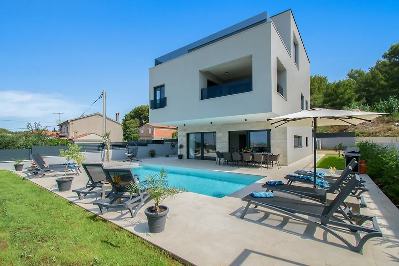 Elegante Ferienwohnung mit Pool, modernen Möbeln und grüner Landschaft.