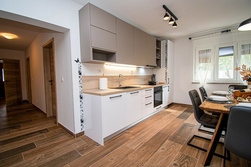 Moderne Küche mit Holzmöbeln, Schränken und Fenstern.