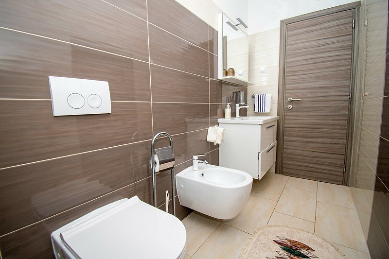 Entspannen Sie sich in diesem stilvollen Badezimmer mit modernen Armaturen und erfrischen Sie sich!