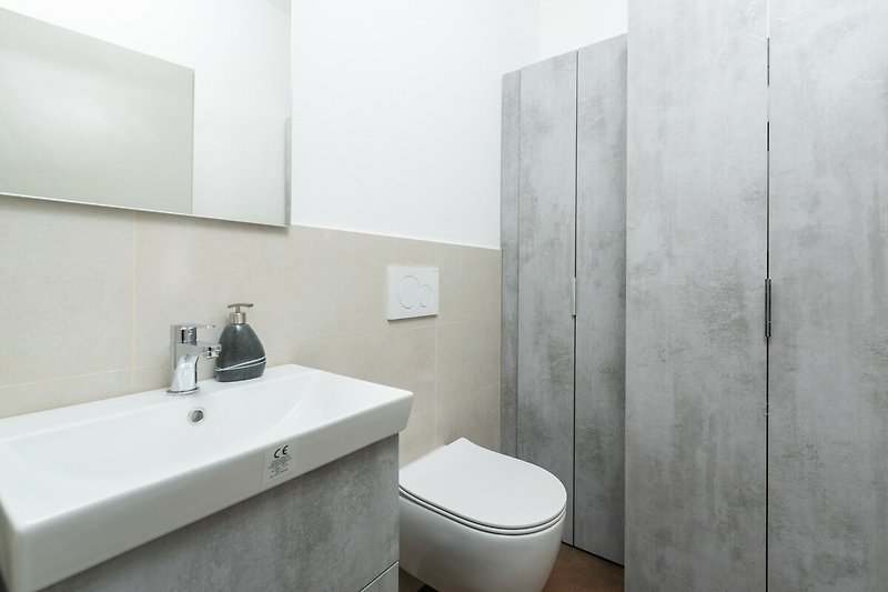Ein stilvolles Badezimmer mit modernem Design und elegantem Wasserhahn.