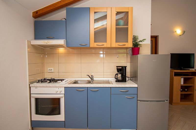 Gemütliche Küche mit Holzmöbeln, Arbeitsplatte und Küchengeräten.