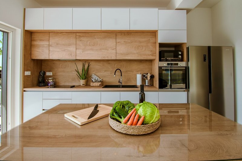 Moderne Küche mit Holzdesign, Schränken und Küchengeräten.