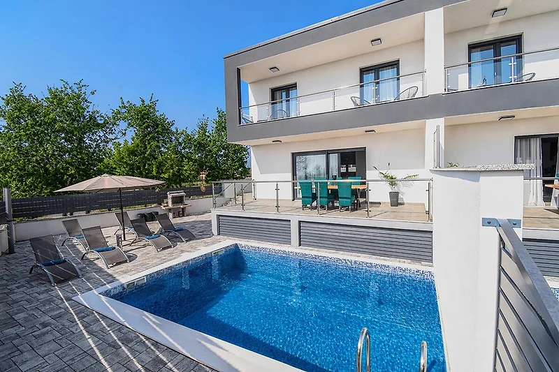 Poollandschaft mit Balkon, Handlauf und Villa im Resort aus Verbundstoff.