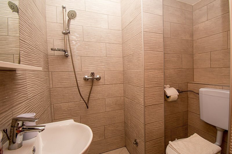 Braune Holz-Waschbecken in einem weißen Badezimmer.