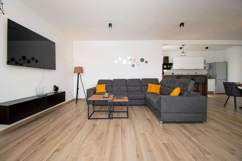 Gemütliches Wohnzimmer mit bequemer Couch, Holzmöbeln und stilvollem Design.