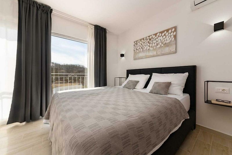 Schlafzimmer mit gemütlichem Bett, Vorhängen und Lampen - entspannende Atmosphäre!
