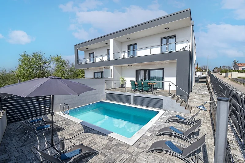 Villa mit Pool und Balkon, umgeben von stilvollem Handlauf.