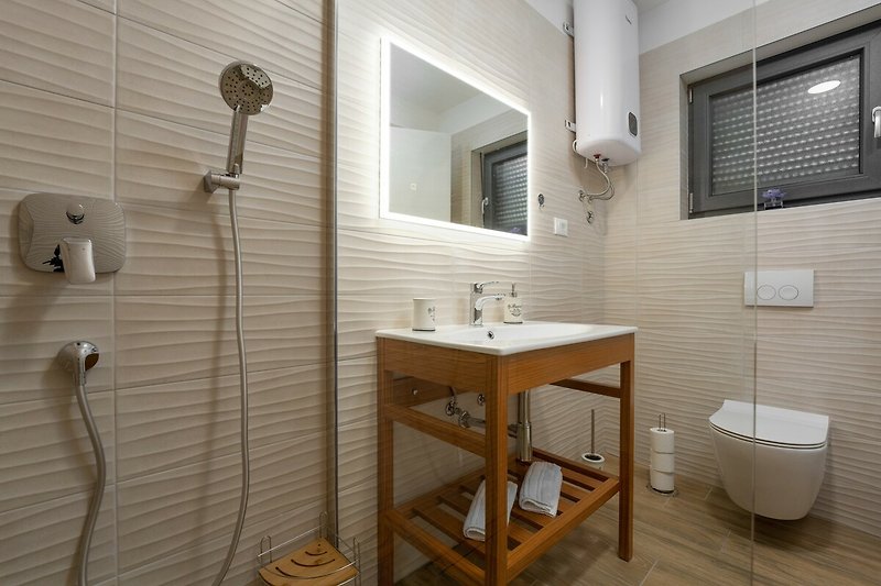 Badezimmer mit Spiegel, Waschbecken und Dusche - modern und funktional.