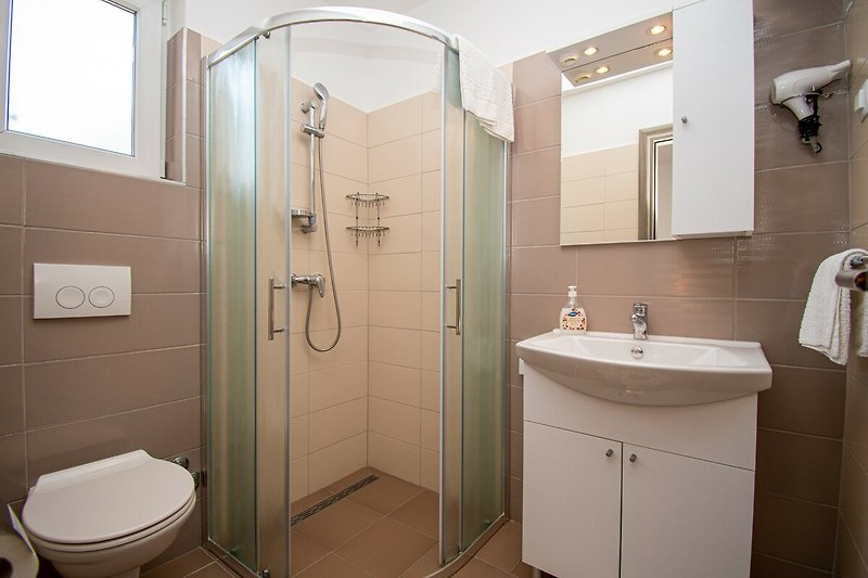 Entspannen Sie sich im lila Badezimmer mit stilvoller Einrichtung und erfrischen Sie sich unter der Dusche.