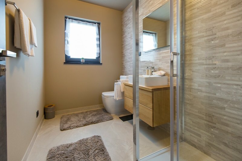 Gemütliches Badezimmer mit Holzboden und stilvoller Einrichtung.