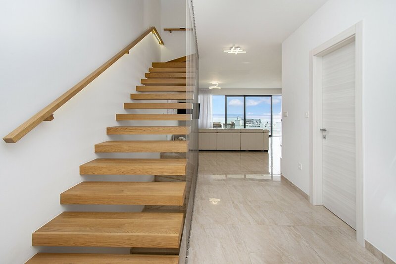 Moderne Treppe mit Holzgeländer und Glasfenster.
