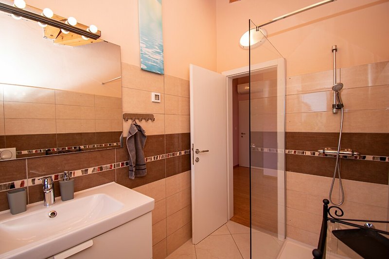 Ein stilvolles Badezimmer mit elegantem Spiegel und moderner Dusche.