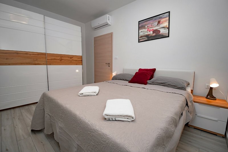 Gemütliches Schlafzimmer mit stilvollem Holzbett und gemütlicher Bettwäsche.