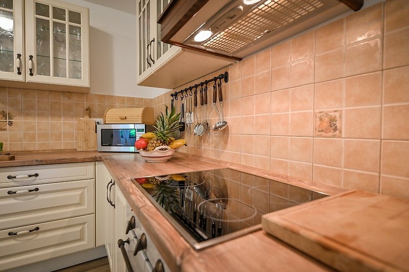 Moderne Küche mit Holz, Granit, Gasofen und Fensterblick.